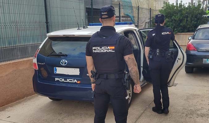 Agentes de la Policía Nacional frente a un coche patrulla.